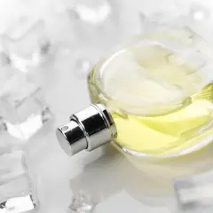 Elegancka butelka perfum z żółtym płynem, otoczona kostkami lodu. Zapach szyprowy, orzeźwiający jak zimny powiew.