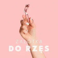 Dłoń trzyma zalotkę do rzęs. Czy zalotka niszczy rzęsy? Dowiedz się więcej o pielęgnacji.