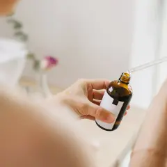 Kobieta aplikuje serum z niacynamidem na dłoń. Bezpieczny wybór dla skóry w ciąży.