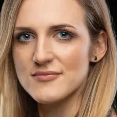 Portret kobiety z niebieskimi oczami i blond włosami, emanującej pewnością siebie i **body positive**.