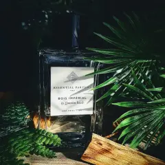 Elegancka butelka perfum Bois Impérial otoczona bujną zielenią i kawałkiem drewna, przywołująca na myśl egzotyczny zapach akigalawood.