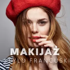 Kobieta w czerwonym beracie i paski na bluzce, z subtelnym makijażem francuskim.
