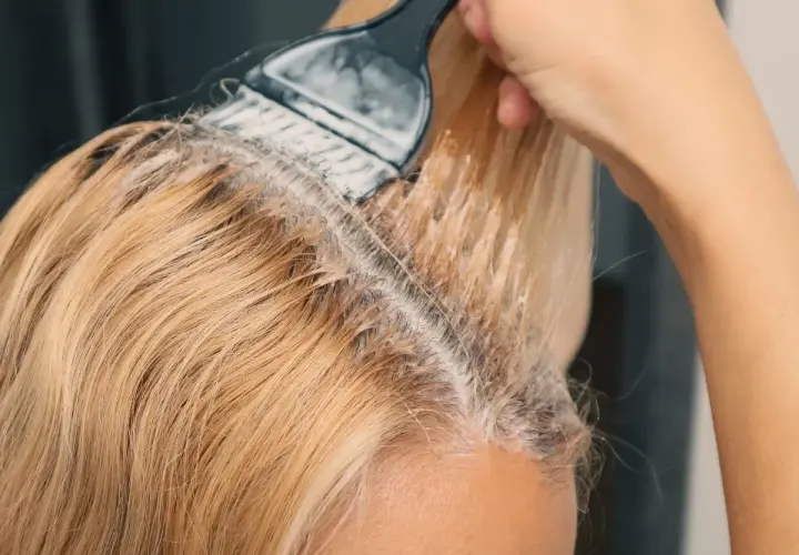 Nakładanie najmniej szkodliwego rozjaśniacza do włosów na blond pasma. Delikatne rozjaśnianie dla pięknego efektu.