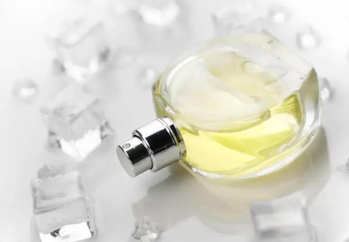 Elegancka butelka perfum z żółtym płynem, otoczona kostkami lodu. Zapach szyprowy, orzeźwiający jak zimny powiew.