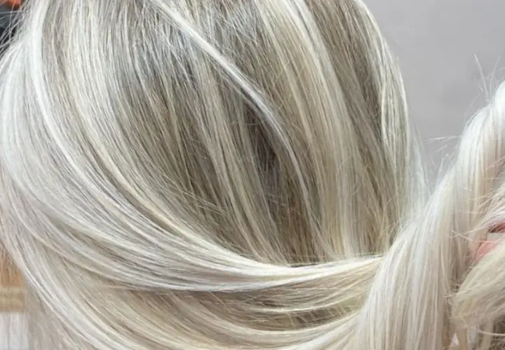 Efektowna dekoloryzacja włosów, tworząca subtelne przejścia między jasnymi blondami a naturalnymi odcieniami.