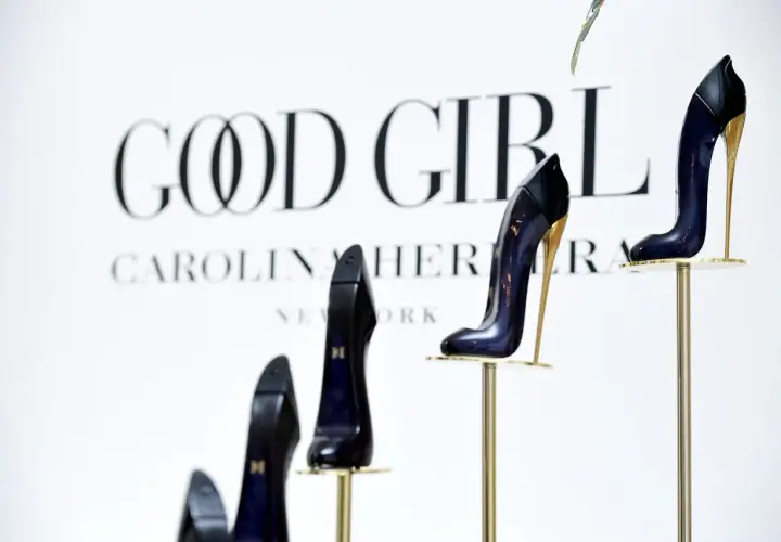 Eleganckie szpilki Good Girl od Carolina Herrera, prezentowane na złotych stojakach, symbolizują odwagę i styl.