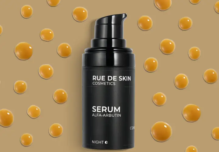 Czarny flakonik serum z alfa arbutyną, otoczony kroplami o bursztynowym kolorze, na beżowym tle.