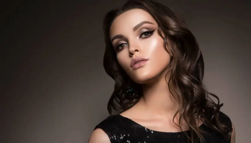 Elegancki makijaż do czarnej sukienki: smoky eyes, błyszczące powieki i matowe usta. Idealny na wieczorne wyjście.