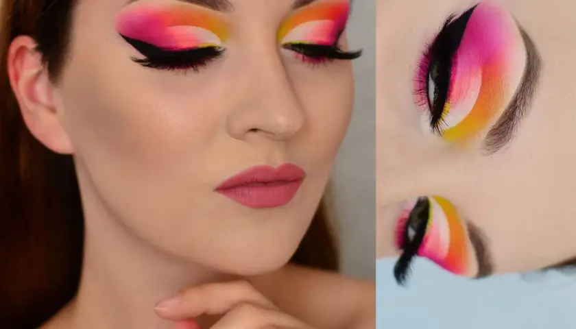 Oczy z wyrazistym makijażem typu cut crease w odcieniach różu, pomarańczy i żółci. Czarne kreski i długie rzęsy podkreślają spojrzenie.