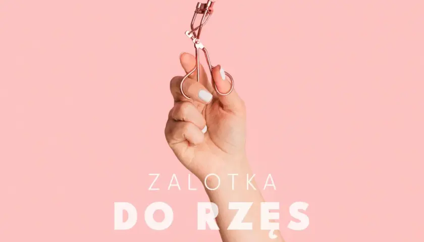 Dłoń trzyma zalotkę do rzęs. Czy zalotka niszczy rzęsy? Dowiedz się więcej o pielęgnacji.