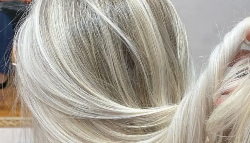 Efektowna dekoloryzacja włosów, tworząca subtelne przejścia między jasnymi blondami a naturalnymi odcieniami.