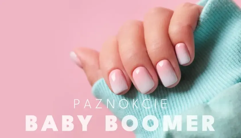 Dłoń z perfekcyjnym manicure baby boomer na różowym tle. Delikatny gradient od różu do bieli na paznokciach.