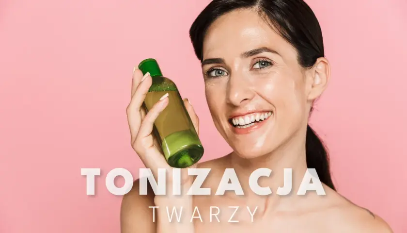 Uśmiechnięta kobieta trzyma butelkę z zielonym płynem, prezentując swoje zdrowe, nawilżone **toniki** do twarzy.
