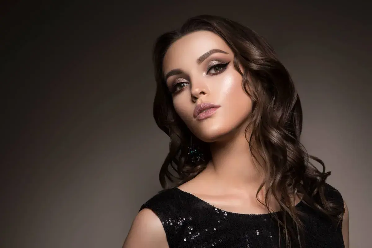 Elegancki makijaż do czarnej sukienki: smoky eyes, błyszczące powieki i matowe usta. Idealny na wieczorne wyjście.