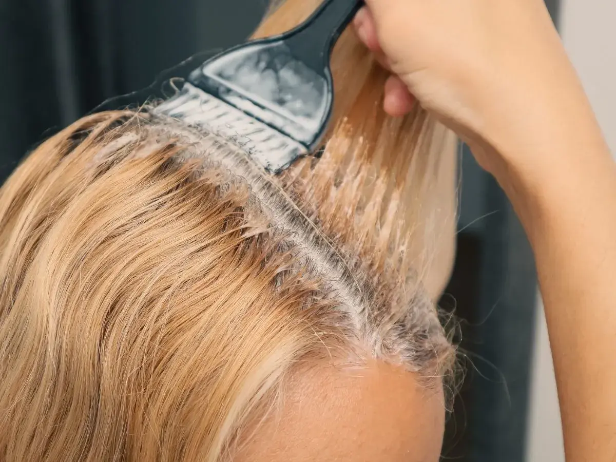 Nakładanie najmniej szkodliwego rozjaśniacza do włosów na blond pasma. Delikatne rozjaśnianie dla pięknego efektu.
