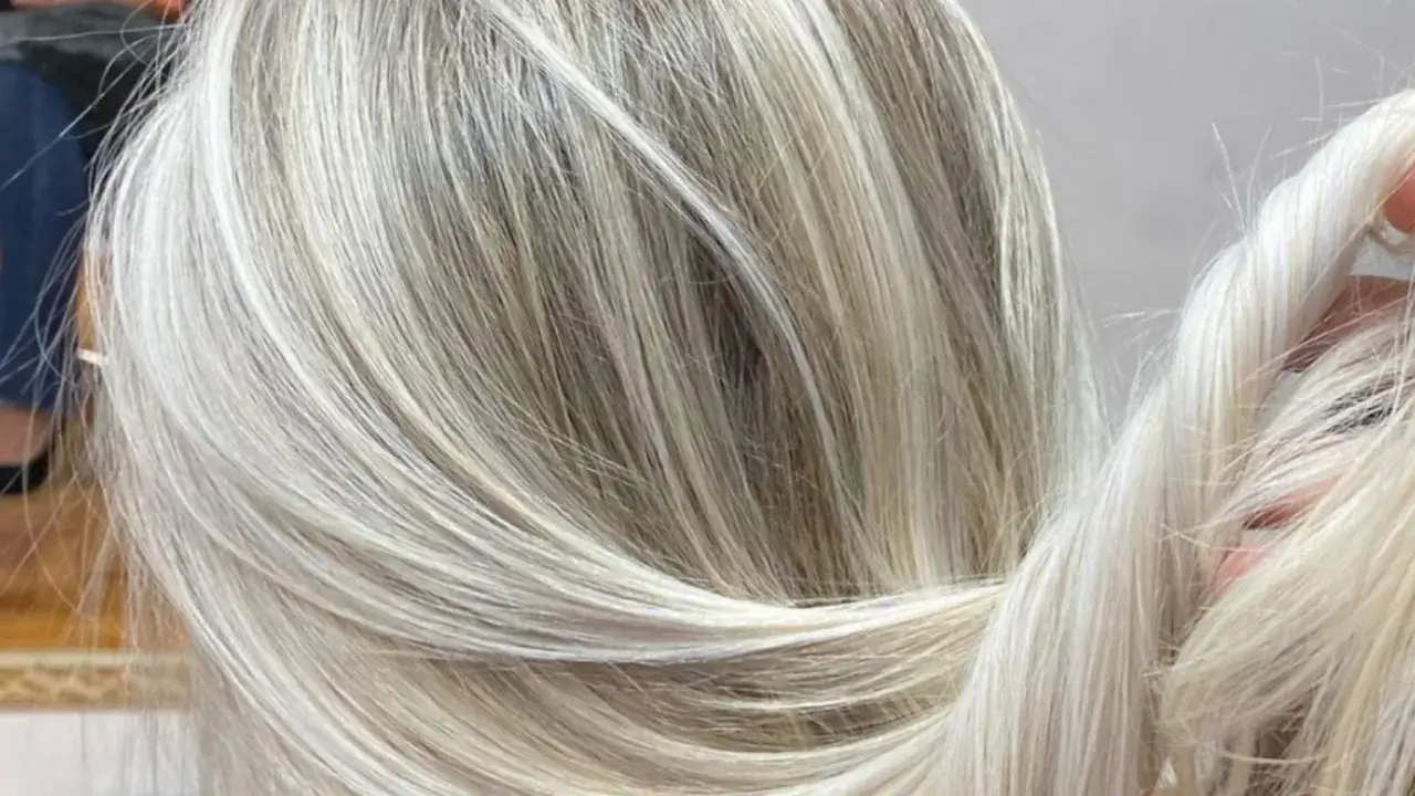 Efektowna dekoloryzacja włosów, tworząca subtelne przejścia między jasnymi blondami a naturalnymi odcieniami.