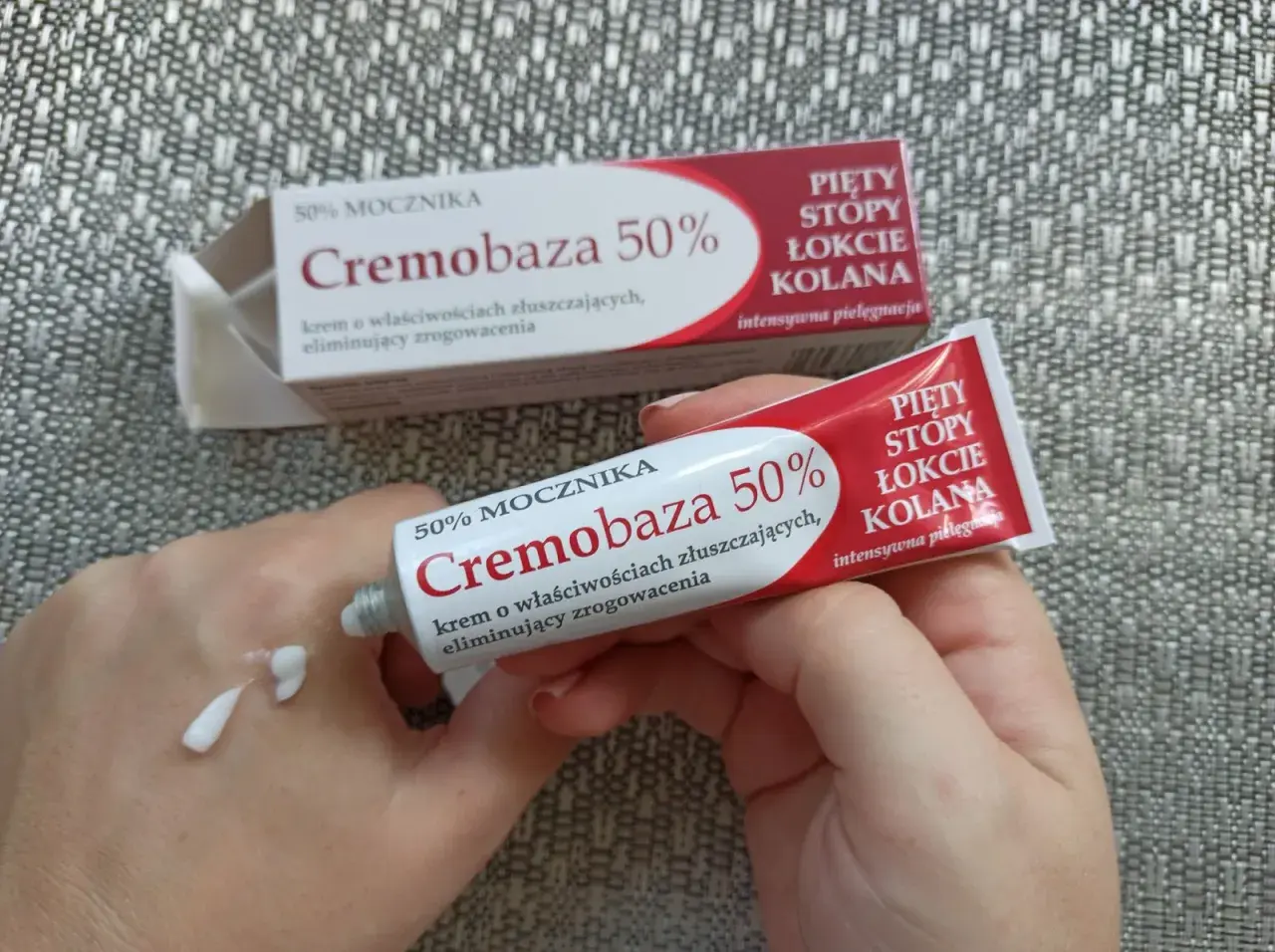Krem Cremobaza 50% na zrogowacenia. Aplikacja na dłoń, widoczna tubka i opakowanie.