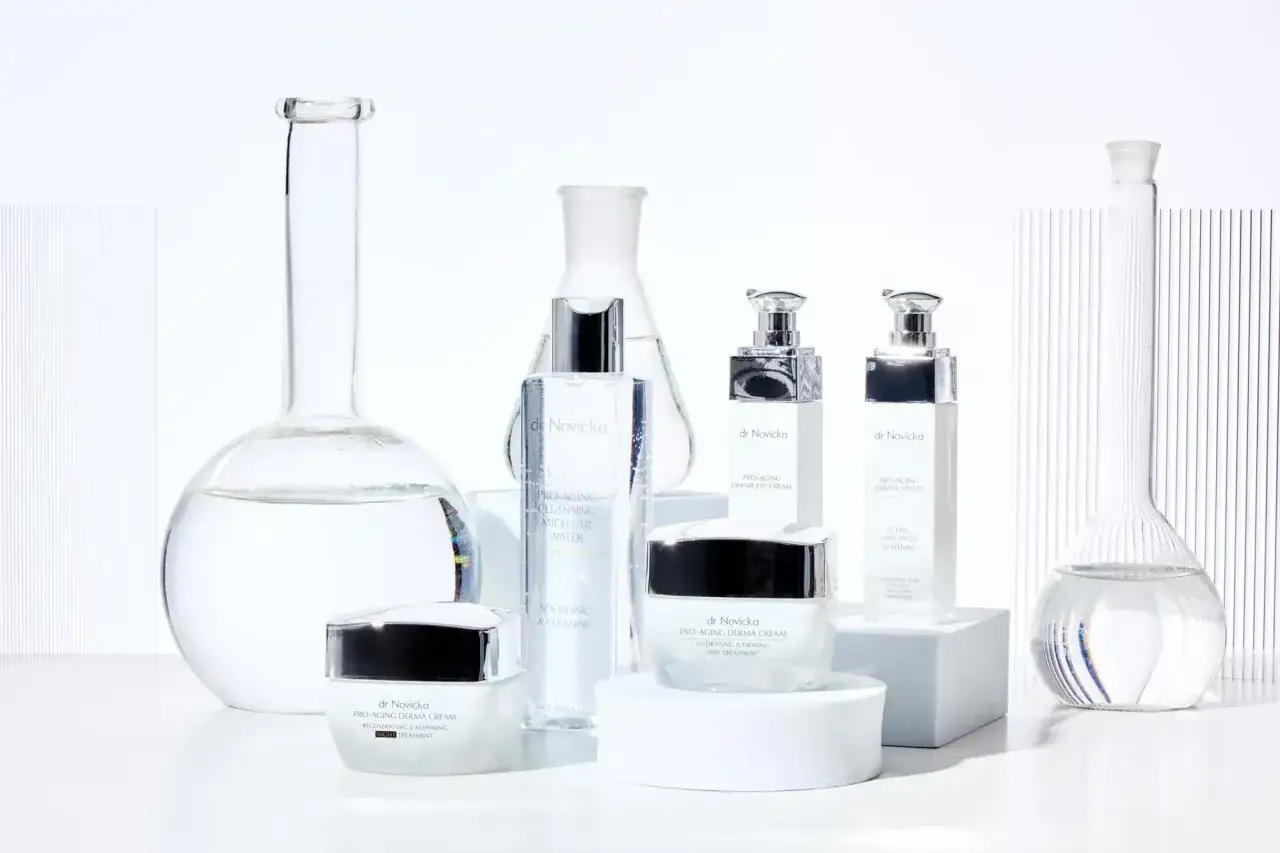 Laboratorium piękna z kosmetykami dr Novicka. Wśród szklanych naczyń, jak w probówkach, znajdziemy kremy i serum, a także płyn micelarny, który może zawierać alkohol benzylowy.