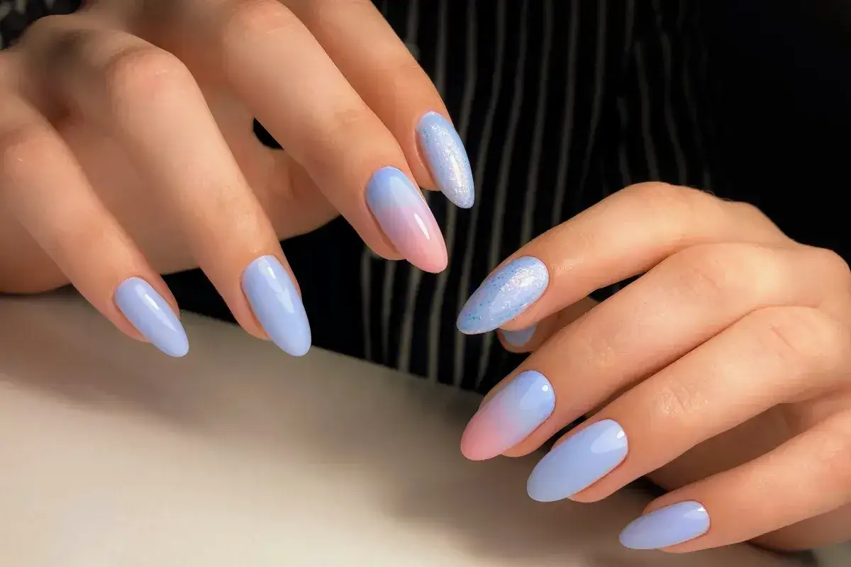 Delikatny manicure baby boomer z pastelowym ombre i brokatem.